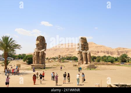 Touristes aux colosses géants de Memnon. Tout ce qui reste du Temple d'Amenhotep III, après un tremblement de terre. Louxor, Égypte Banque D'Images