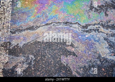 Les taches d'huile et de gaz d'une voiture marquent la surface de l'asphalte de stationnement Banque D'Images