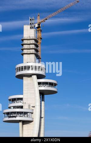 Une tour d'observation moderne située sur une colline, offrant une vue imprenable sur le paysage urbain et le paysage environnant sous un ciel bleu clair. Banque D'Images