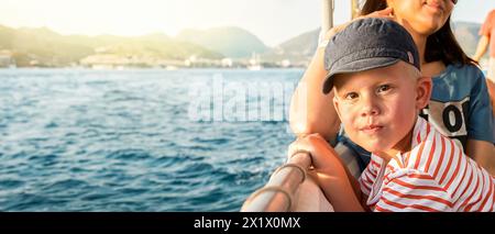 Mignon tout-petit avec mère aime le voyage en bateau naviguant dans la mer au-delà de la côte de Marmaris. Portrait d'un garçon en casquette de protection solaire en vacances en Turquie grand plan Banque D'Images