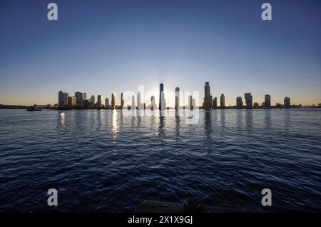 Lever du soleil sur East River avec les gratte-ciel du quartier de long Island City Queens derrière. Vu de East River Esplanade East Mid Town, New York Banque D'Images