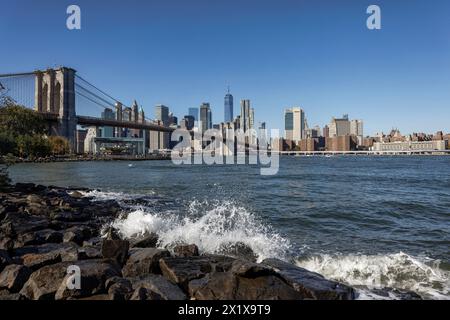 Lower Manhattan gratte-ciel derrière East River et Brooklyn Bridge vu de Pebble Beach, main Street Park, Brooklyn, New York Banque D'Images