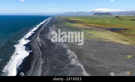 Longue plage noire vue depuis le promontoire de Dyrholaey avec le volcan Eyafjiallajokull en arrière-plan Banque D'Images