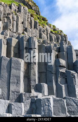 Colonnes de basalte à la base de la falaise de Reynisfjall sur la plage de Reynisfjara dans la falaise sud de l'Islande Banque D'Images