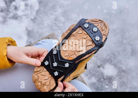 Pointes en acier inoxydable pour la traction sur la glace et la neige sous forme de revêtement en caoutchouc pour les bottes. Banque D'Images