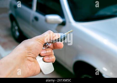 Prise de vue d'un homme appuyant sur la télécommande des systèmes d'alarme de la voiture Banque D'Images