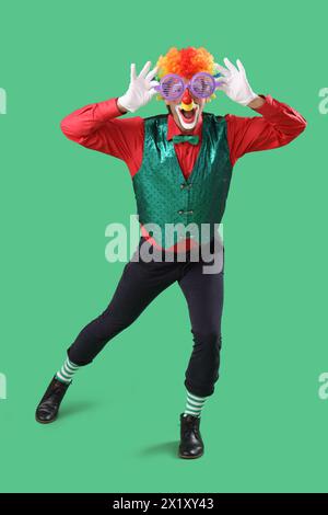 Portrait de clown avec des lunettes de nouveauté sur fond vert. Fête du fou d'avril Banque D'Images