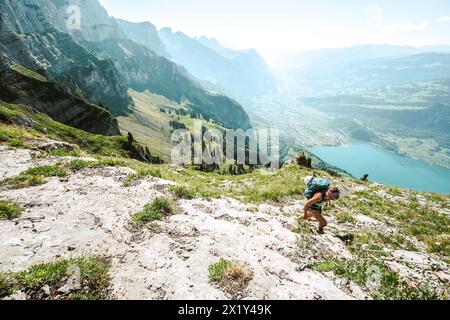 Description : une femme sportive monte de Walensee à Churfürsten le matin. Schnürliweg, Walensee, composé Gallen, Suisse, Europe. Banque D'Images