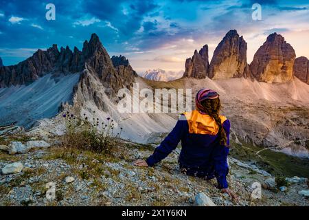 Description : femme sportive bénéficie d'une vue épique depuis Sextner Stein sur Monte Paterno et la chaîne de montagnes Tre Cime dans la soirée. Tre Cime, Dolomites, Sout Banque D'Images