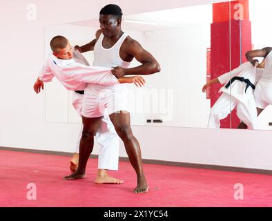 Deux hommes adault pratiquant des techniques d'autodéfense dans la salle de sport Banque D'Images