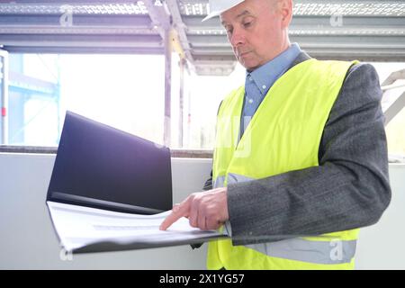 constructeur âgé expérimenté, chef d'équipe de construction, ingénieur de construction en protection de casque blanc signe des documents sur le chantier de construction pour la construction Banque D'Images