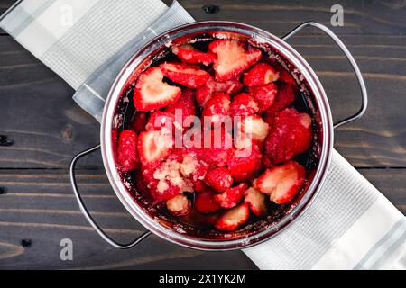 Fraises macérées dans un petit four hollandais : tranches de fraises après macération avec du sucre de canne biologique dans une cocotte Banque D'Images