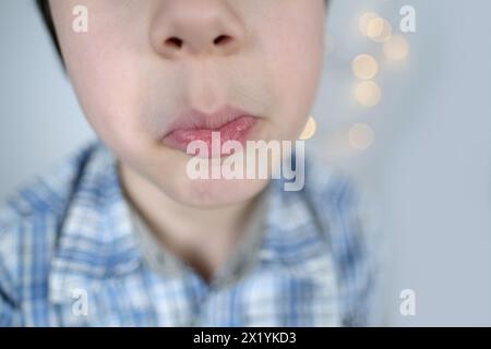 visage drôle de petit enfant, enfant effectue des exercices d'articulation pour la bouche, la cavité buccale, gros plan, effectue des exercices d'articulation pour la langue, acteur Banque D'Images