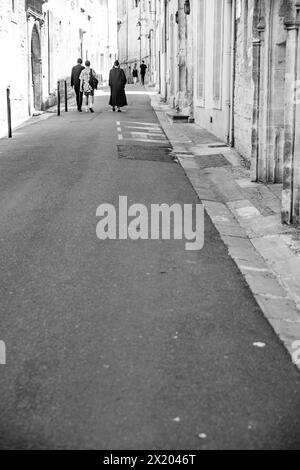 Un groupe de personnes marchant dans les rues d'Arles, France. Banque D'Images