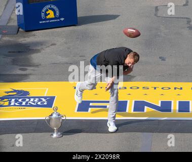 Boston, Massachusetts, États-Unis 15 avril 2024 ancien joueur de la National Football League, de longue date New England Patriots Tight End et Grand Marshall du 128e Marathon de Boston pointe le football à la ligne d'arrivée du Marathon à Copley Square, Boston, Massachusetts, États-Unis le 15 avril 2024. (Rick Friedman/Polaris ) Banque D'Images