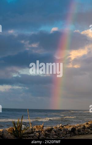 Arc-en-ciel au-dessus de la plage de la mer de Tasman suite à une tempête à Hokitika en Nouvelle-Zélande Banque D'Images