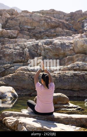 Femme biraciale, cheveux foncés, en vêtements de sport, embrasse l'aventure naturelle brute Banque D'Images