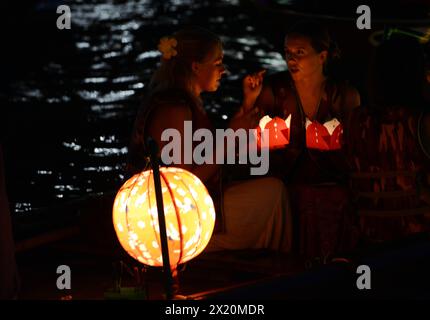 Lanterne éclairée bateaux en bois emmènent les habitants et les touristes sur un voyage sur la rivière Thu bon dans la vieille ville de Hoi an, Vietnam. Banque D'Images