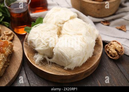 Bonbons orientaux. Savoureux pashmak iranien et thé sur une table en bois, gros plan Banque D'Images