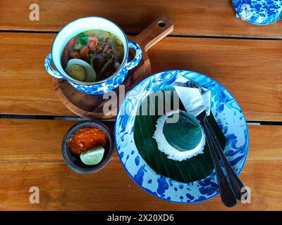Soto Lamongan servi dans des faïences vintage, évoquant les vibrations nostalgiques du village, parfait pour mettre en valeur le patrimoine culinaire indonésien authentique Banque D'Images