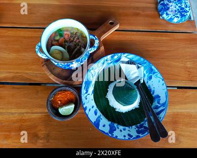 Soto Lamongan servi dans des faïences vintage, évoquant les vibrations nostalgiques du village, parfait pour mettre en valeur le patrimoine culinaire indonésien authentique Banque D'Images