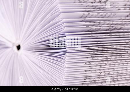 un livre avec des pages pliées se présente comme un magasin analogique de connaissances, image rapprochée avec de vraies ombres Banque D'Images