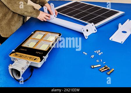 Assemblage de l'éclairage de rue LED avec panneau solaire, le propriétaire prépare le support de montage. Banque D'Images