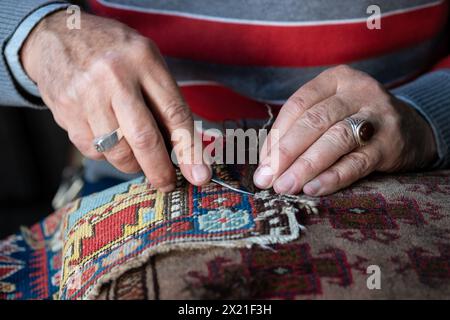 Mains d'artisan restauration de tapis vintage en Syrie Banque D'Images