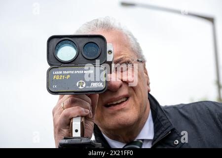 19 avril 2024, Bavière, Nuremberg : le ministre bavarois de l'intérieur Joachim Herrmann (CSU) regarde à travers un appareil de mesure de vitesse. Jusqu'à 6 heures du matin le samedi 20 avril, environ 2 000 policiers et autres agents municipaux de contrôle de la circulation effectueront des mesures de vitesse à environ 1 500 points de mesure possibles dans toute la Bavière. Photo : Pia Bayer/dpa Banque D'Images