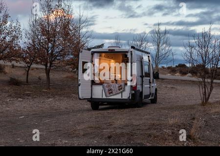 Camping-car garé devant un lac au coucher du soleil. Concept van vie, style de vie, transport, vacances, tourisme Banque D'Images