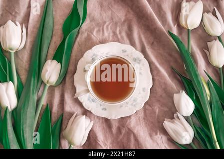 Tasse de thé entourée de tulipes blanches Banque D'Images