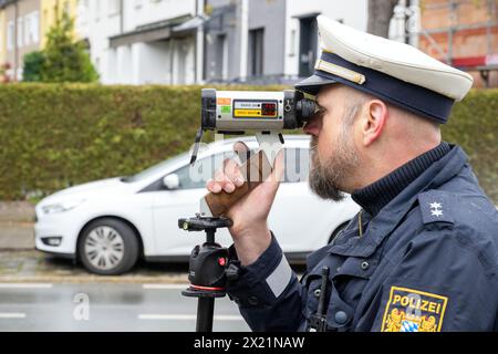 19 avril 2024, Bavière, Nuremberg : un policier regarde à travers un appareil de mesure de vitesse. Jusqu'à 6 heures du matin le samedi 20 avril, environ 2000 policiers et autres agents municipaux de contrôle de la circulation effectueront des mesures de vitesse à environ 1500 points de mesure possibles dans toute la Bavière. Photo : Pia Bayer/dpa Banque D'Images