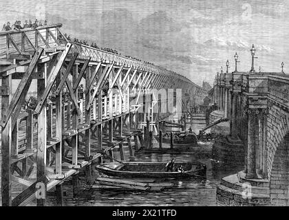 Pont temporaire sur la Tamise à Blackfriars, [Londres], 1864. 'Le vieux pont Blackfriars, qui a été pendant un certain temps dans un état très fou, doit être rapidement reconstruit; et, comme la fermeture d'une artère aussi importante se ferait avec des inconvénients très graves [...], la Corporation de la ville de London a très justement déterminé, en faisant ériger une structure temporaire à cette fin [...] sa position se situe entre le nouveau pont en cours de construction pour le London, Chatham, et la Dover Railway Company, située à quelques mètres à l'est de celle-ci, et le vieux pont Blackfriars... et avec t Banque D'Images