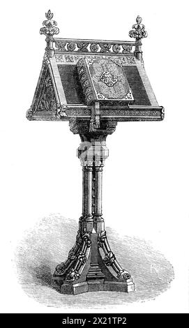 Pupitre et Bible présentés au prince de Galles, 1864. « Nous avons gravé une photographie du Lectern en chêne sculpté ou bureau de lecture, avec la Bible dessus, qui ont été, avec un livre de prières commun, présentés dernièrement au prince de Galles par le comte de Dalhousie, le comte de Shaftesbury, Lord Charles Russell, le Honor A. Kinnaird, et d'autres messieurs, au nom de plus de huit mille abonnés d'un shilling chacun, en signe de leur attachement loyal au fils de notre reine, avec leurs sincères félicitations pour son mariage. La députation, au nombre d'une vingtaine, avait un interv Banque D'Images