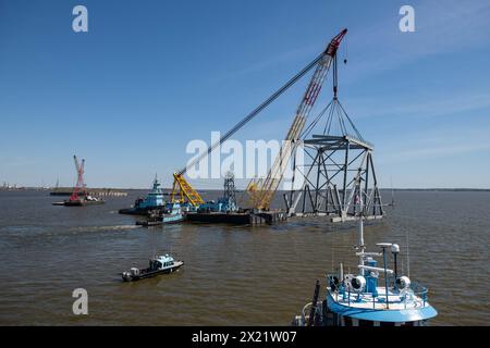 Dundalk (États-Unis d'Amérique). 16 avril 2024. Le Chesapeake, une barge de derrick d'une capacité de levage de 1000 tonnes, soulève une section du pont Francis Scott Key qui bloque le chenal de Fort McHenry, le 16 avril 2024, près de Dundalk, dans le Maryland. Le pont a été heurté par le porte-conteneurs de 984 pieds le 26 mars et s'est effondré tuant six travailleurs. Crédit : MC2 Christine Montgomery/U.S. Navy photo/Alamy Live News Banque D'Images