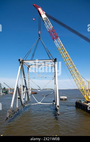 Dundalk (États-Unis d'Amérique). 16 avril 2024. Le Chesapeake, une barge de derrick d'une capacité de levage de 1000 tonnes, soulève une section du pont Francis Scott Key qui bloque le chenal de Fort McHenry, le 16 avril 2024, près de Dundalk, dans le Maryland. Le pont a été heurté par le porte-conteneurs de 984 pieds le 26 mars et s'est effondré tuant six travailleurs. Crédit : MC2 Christine Montgomery/U.S. Navy photo/Alamy Live News Banque D'Images