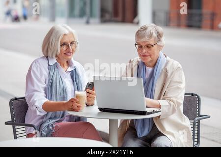 Femmes d'affaires âgées à la réunion d'affaires dans un café en plein air dans la ville. Belles femmes âgées matures avec les cheveux gris discuter des affaires avec a la Banque D'Images