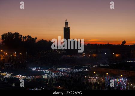 Marrakech, Maroc - janvier 28 2019 : Jemaa el-Fnaa au coucher du soleil avec la mosquée Koutoubia derrière. Banque D'Images