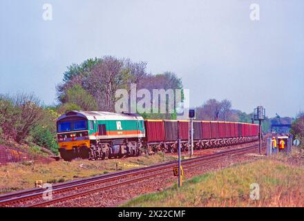 Une locomotive diesel de classe 59 numéro 59002 dans la livrée courte durée de Mendip Rail travaillant un train de wagons de pierre vides à Worting Junction le 23 avril 2002. Banque D'Images