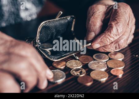 Photo détaillée en gros plan de femmes âgées de 96 ans comptant les pièces restantes de la pension dans son portefeuille après avoir payé les factures. Non-viabilité des transferts sociaux et du système de retraite Banque D'Images
