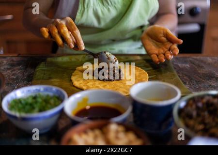 Gros plan des mains préparant hallaca ou tamale. Concept de nourriture traditionnelle Banque D'Images