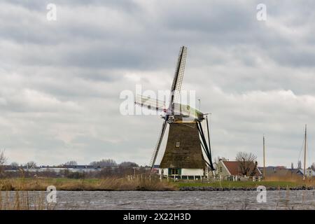 Vue sur le toit de chaume historique Veendermolen avec la maison de miller sur le sein de la Weide AA près du village hollandais de Roelofarendsveen contre le b. Banque D'Images