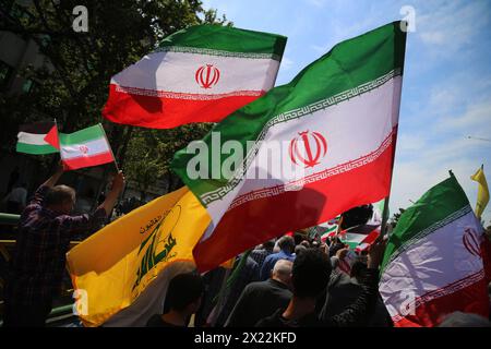 19 avril 2024, Téhéran, Iran : les Iraniens brandissent des drapeaux de l'Iran et du Hezbollah lors d'un rassemblement anti-israélien à Téhéran. Les systèmes de défense aérienne au-dessus de la ville centrale d'Ispahan ont détruit trois objets aériens tôt le 19 avril. Les explosions surviennent après une attaque par drone et missile menée par le corps des Gardiens de la révolution islamique (CGRI) contre Israël le 13 avril, à la suite d'une frappe aérienne contre l'ambassade iranienne en Syrie, qui, selon l'Iran, a été menée par Israël. r de la guerre en GaCredit : Zuma Press/Alamy Live News Banque D'Images