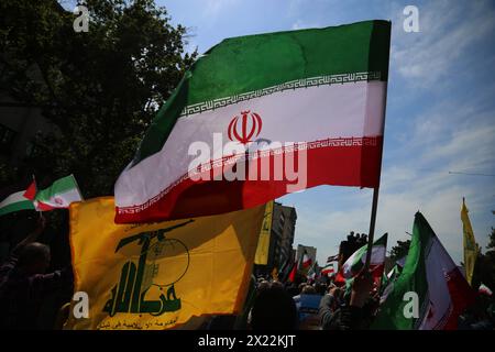 19 avril 2024, Téhéran, Iran : les Iraniens brandissent des drapeaux de l'Iran et du Hezbollah lors d'un rassemblement anti-israélien à Téhéran. Les systèmes de défense aérienne au-dessus de la ville centrale d'Ispahan ont détruit trois objets aériens tôt le 19 avril. Les explosions surviennent après une attaque par drone et missile menée par le corps des Gardiens de la révolution islamique (CGRI) contre Israël le 13 avril, à la suite d'une frappe aérienne contre l'ambassade iranienne en Syrie, qui, selon l'Iran, a été menée par Israël. r de la guerre en GaCredit : Zuma Press/Alamy Live News Banque D'Images