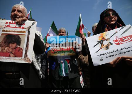 19 avril 2024, Téhéran, Iran : Iraniens portant des pancartes lors d'un rassemblement anti-israélien à Téhéran. Les systèmes de défense aérienne au-dessus de la ville centrale d'Ispahan ont détruit trois objets aériens tôt le 19 avril. Les explosions surviennent après une attaque par drone et missile menée par le corps des Gardiens de la révolution islamique (CGRI) contre Israël le 13 avril, à la suite d'une frappe aérienne contre l'ambassade iranienne en Syrie, qui, selon l'Iran, a été menée par Israël. r de la guerre de Gaza, avec IraniaCredit : Zuma Press/Alamy Live News Banque D'Images