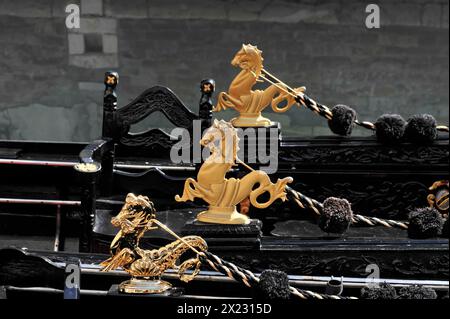 Plusieurs sculptures dorées sur les gondoles noires sur fond sombre, Venise, Vénétie, Italie Banque D'Images