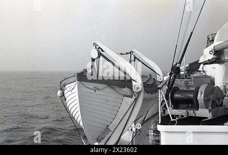 Années 1950, historique, un canot de sauvetage suspendu sur des bosses sur le MS Kungsholm sur un navire de croisière suédois de la Sweden-America Lines (SAL). SAGA 9 marquée sur le côté des bateaux. Construit en 1953 pour Svenska Amerika Linien (SAL), il s'agissait d'un paquebot/bateau de croisière combiné, offrant des traversées transatlantiques de Gothenburg à New York pendant l'été et des croisières de luxe pendant d'autres parties de l'année. Il a cessé son service en 1965. Banque D'Images