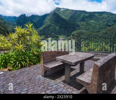 Banc en béton et table avec belle vue sur les collines verdoyantes et la vallée du lieu de repos, point de vue à Sao Roque do Faial Santana , Madère île, n Banque D'Images