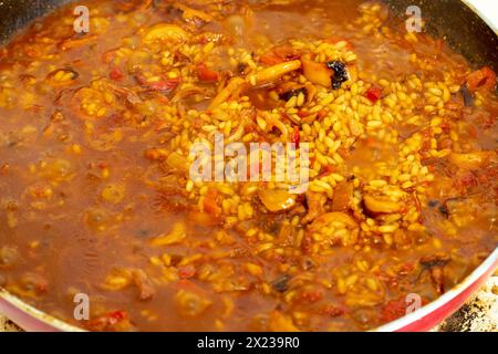 Plongez-vous dans l'art de la cuisine espagnole tandis que les couleurs vibrantes et les arômes séduisants de la paella prennent vie lors de sa préparation Banque D'Images