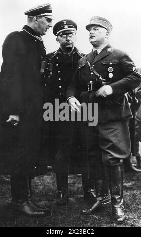 Années 1930 - Allemagne - Ernst Roehm (à droite), chef nazi des troupes de tempête, discute d'une revue de troupes avec le chef de la Gestapo Heinrich Himmler et un subordonné, Gruppenfuhrer Daluege. Banque D'Images